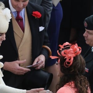 Kate Middleton avec des invités lors d'une garden party organisée dans les jardins de Buckingham Palace le 24 mai 2016.