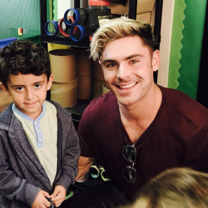 Zac Efron dévoile sa nouvelle coupe de cheveux, similaire à celle de Justin Bieber lors des American Music Awards 2015, alors qu'il rend visite à des enfants dans une école primaire. Photo publiée sur Twitter, le 2 juin 2016
