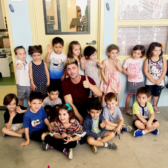 Zac Efron arbore une nouvelle coupe de cheveux, similaire à celle de Justin Bieber lors des American Music Awards 2015, alors qu'il rend visite à des enfants dans une école primaire. Photo publiée sur Twitter, le 2 juin 2016