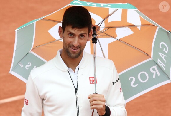 Novak Djokovic aux internationaux de France de Roland Garros sous un parapluie le 31 mai 2016, lors de son match en huitième de finale contre Roberto Bautista-Agut. © Dominique Jacovides / Bestimage