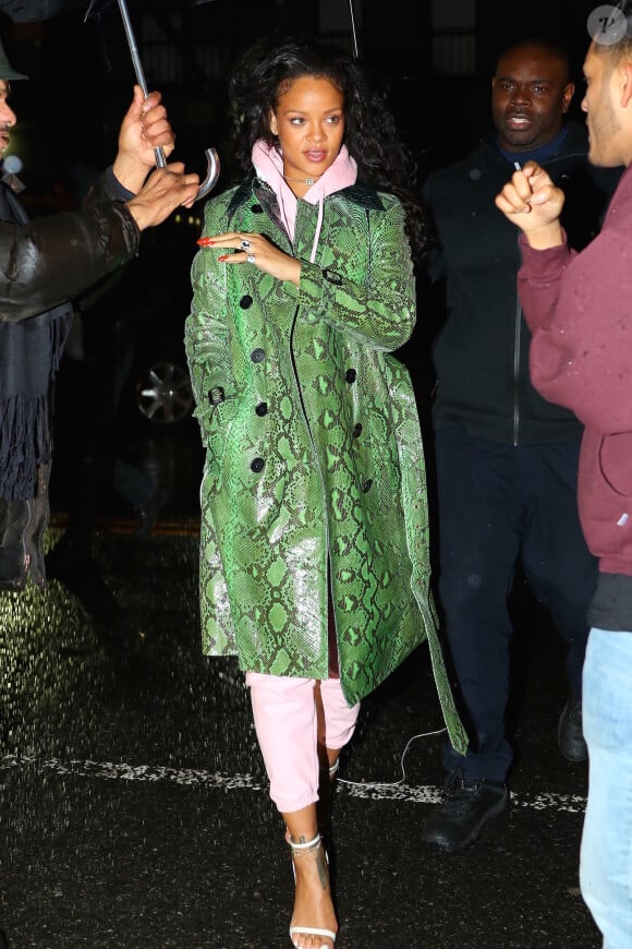 Rihanna se rend à l'Up & Down à New York, habillée d'un trench-coat en python Burberry (collection printemps-été 2017), d'un pull et d'un jogging roses Vetements (collaboration Vetements x Champion) et de sandales Tom Ford (modèle Padlock). Le 10 janvier 2017.