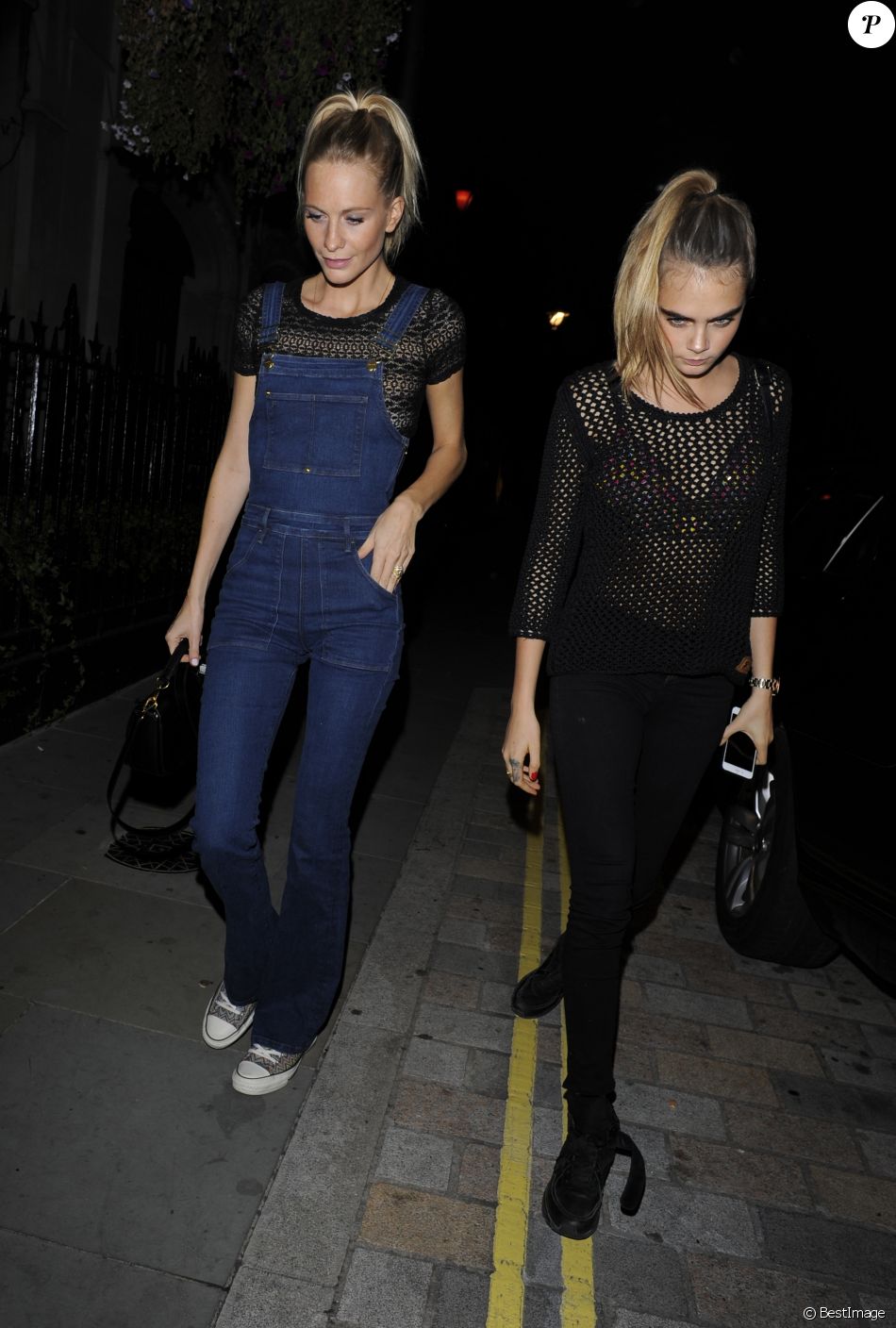 Cara (chaussures Chanel) et Poppy Delevingne (salopette Frame Denim,  chaussures Converse) vont dîner à Londres le 3 octobre 2014. - Purepeople