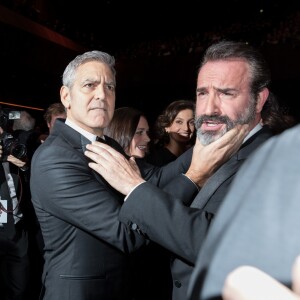 George Clooney (montre Omega) retrouve son complice Jean Dujardin à la 42e cérémonie des César à la salle Pleyel à Paris le 24 février 2017. © Olivier Borde / Dominique Jacovides / Bestimage