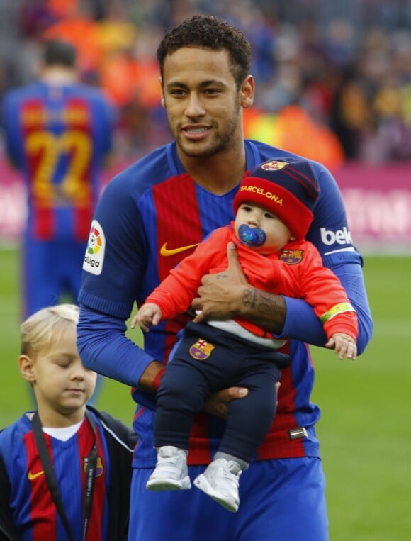 Le footballeur du FC Barcelone Neymar pose avec son fils Davi Lucca ( blond) et un bébé à Barcelone le 4 février 2017