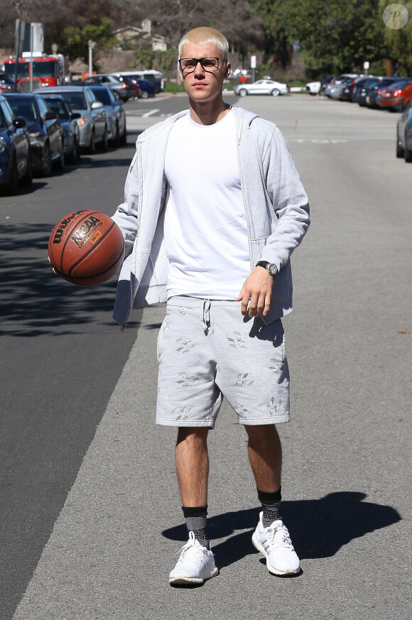 Justin Bieber se promène un ballon de basket à la main à Los Angeles, le 23 février 2017.