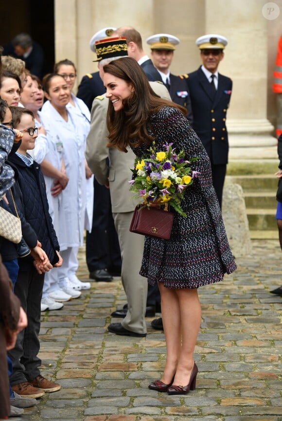 Le prince William, duc de Cambridge et Kate Middleton visitent les Invalides à Paris le 18 mars 2017. La duchesse de Cambridge a rendu hommage à la France en choisissant un manteau, un sac et une ceinture Chanel.