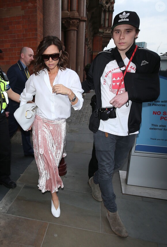 Victoria Beckham et son fils Brooklyn (le bras gauche en écharpe) sont escotés par la police quand ils arrivent à la gare St Pancras à Londres, Royaume Uni, le 11 mars 2017, en provenance de Paris. C