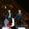 Emmanuel Macron, élu président de la république, et sa femme Brigitte Macron, saluent les militants devant la pyramide au musée du Louvre à Paris, après sa victoire lors du deuxième tour de l'élection présidentielle. Le 7 mai 2017
