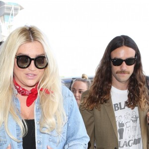 Kesha et son compagnon Brad Ashenfelter arrivent à l'aéroport de LAX à Los Angeles. Kesha fait un doigt d'honneur aux photographes! Le 1er juin 2017