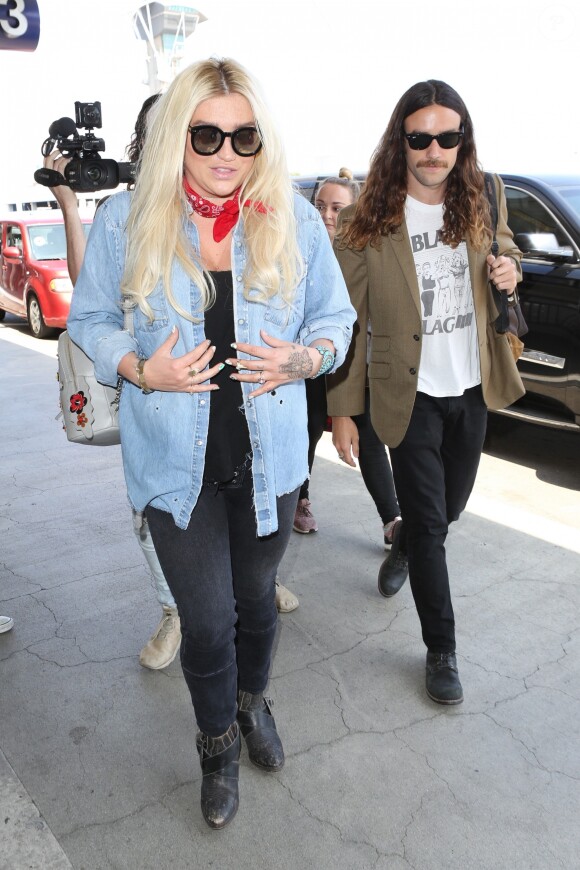 Kesha et son compagnon Brad Ashenfelter arrivent à l'aéroport de LAX à Los Angeles. Kesha fait un doigt d'honneur aux photographes! Le 1er juin 2017