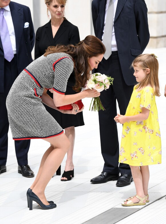 La duchesse Catherine de Cambridge, superbe dans une nouvelle robe Gucci, recevant un bouquet de la part de la petite Lydia Hunt le 29 juin 2017 lors de l'inauguration d'une nouvelle aile du Victoria and Albert Museum, dans le quartier de South Kensington à Londres.