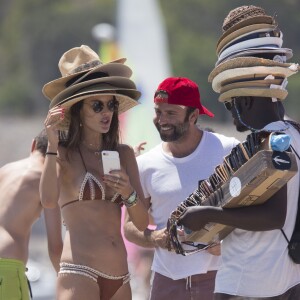 Exclusif - Alessandra Ambrosio essaye des chapeaux sur une plage d'Ibiza le 9 juillet 2017.