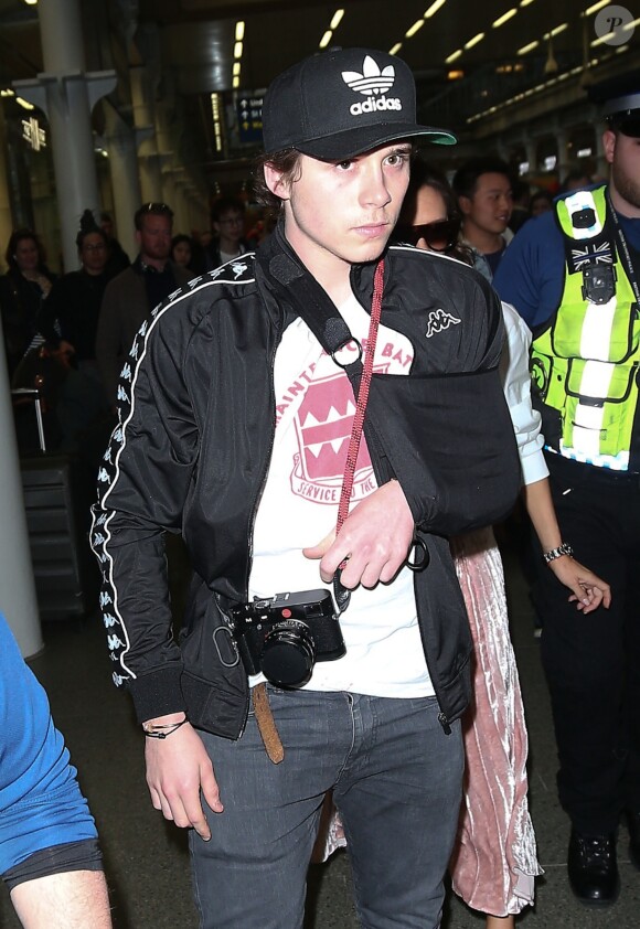 Victoria Beckham et son fils Brooklyn sont escortés par la police quand ils arrivent à la gare St Pancras à Londres, le 11 mars 2017, en provenance de Paris.