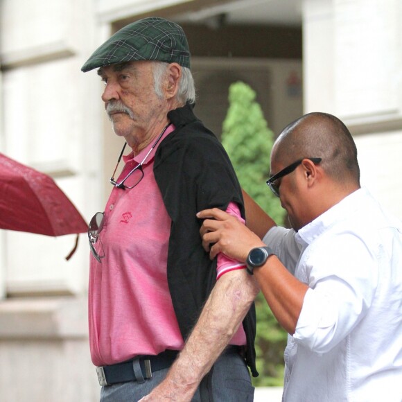 Sean Connery marche avec l'aide d’un assistant à la sortie d’un spa où il a passé 2 heures dans le quartier de Manhattan à New York, le 29 août 2017