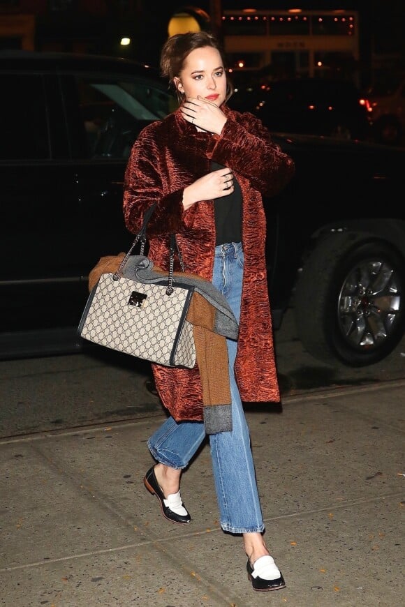 Dakota Johnson a passé la journée sur un shooting photo avec les acteurs de 'Fifty Shades Freed' à New York. L'actrice porte un manteau en fourrure marron, un jean taille haute, un haut noir, des mocassins noirs et blancs et un sac 'Gucci', le 2 novembre 2017.
