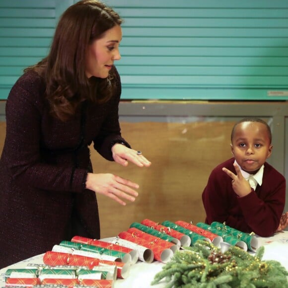 Une partie de pierre-feuille-ciseaux ? La duchesse Catherine de Cambridge, enceinte, a remis des cadeaux aux enfants lors d'une fête de Noël organisée au Rugby Portobello Trust, dans le quartier de North Kensington à Londres, le 12 décembre 2017.