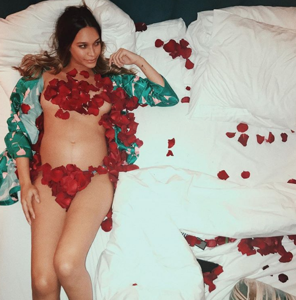 April Love Geary (enceinte) pose nue couverte de pétales sur une photo publiée sur Instagram le 6 décembre 2017