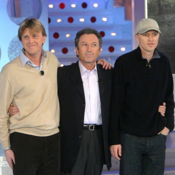 Michel Drucker au côté des fils de Claude François, Claude François Junior et Marc François, sur le plateau de l'émission Vivement Dimanche en janvier 2004