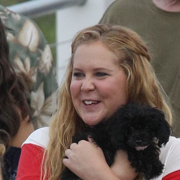 Exclusif - Amy Schumer câline son petit chien Tati et mange un hot dog dans les rues de Salisbury, le 14 août 2017