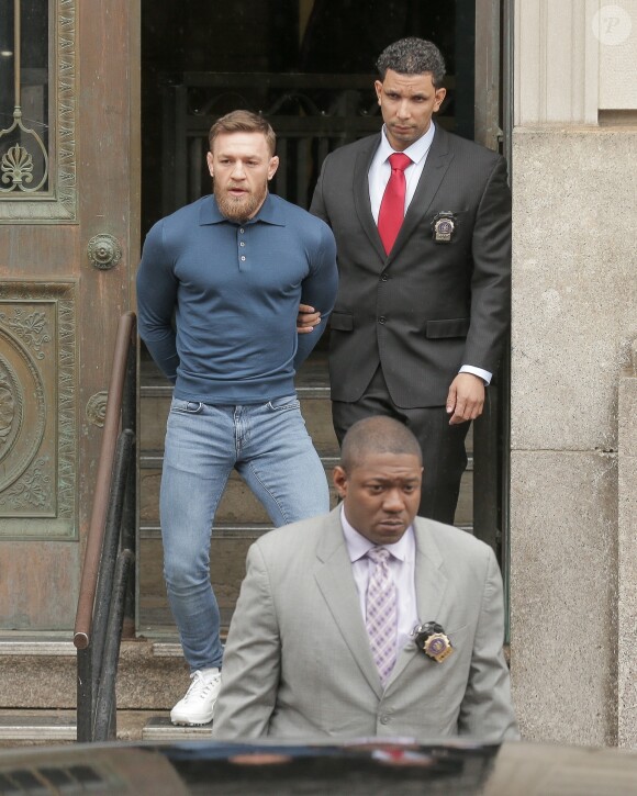 Conor McGregor, menotté, quittant le commissariat de Brooklyn pour aller au tribunal le 6 avril 2018 à New York au lendemain de son attaque contre un bus de combattants de l'UFC.