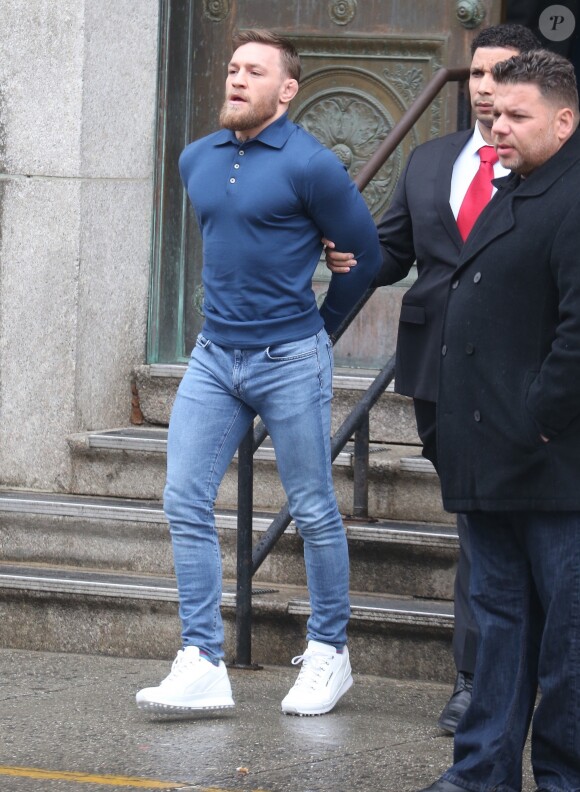 Conor McGregor, menotté, quittant le commissariat de Brooklyn pour aller au tribunal le 6 avril 2018 à New York au lendemain de son attaque contre un bus de combattants de l'UFC.