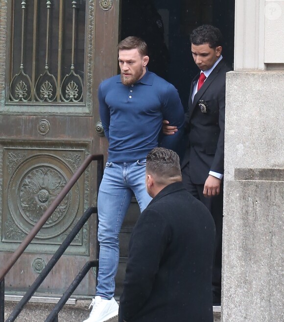 Conor McGregor, menotté, quittant le commissariat de Brooklyn pour aller au tribunal le 6 avril 2018 à New York au lendemain de son attaque contre un bus de combattants de l'UFC.