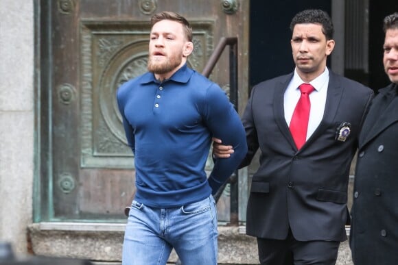 Conor McGregor, menotté, quittant le commissariat de Brooklyn pour aller au tribunal le 6 avril 2018 à New York au lendemain de son attaque contre un bus de combattants de l'UFC.