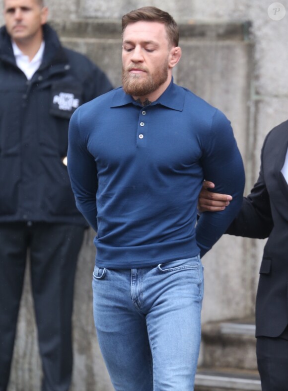 Conor McGregor, menotté, quittant le commissariat de Brooklyn pour aller au tribunal le 6 avril 2018 à New York au lendemain de son attaque contre un bus de combattants de l'UFC.