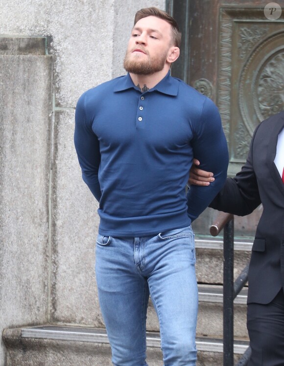 Conor McGregor, menotté, quittant le commissariat de Brooklyn pour aller au tribunal le 6 avril 2018 à New York au lendemain de son attaque contre un bus de combattants de l'UFC.