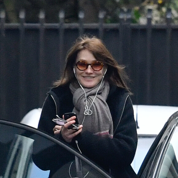 Semi-exclusif - Carla Bruni-Sarkozy quitte son domicile de Neuilly-sur-Seine très souriante le 23 mars 2018.