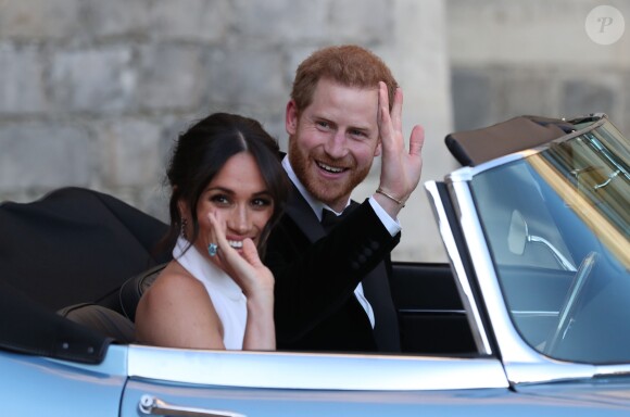 Le prince Harry, duc de Sussex, et Meghan Markle, duchesse de Sussex, habillée d'une robe Stella McCartney et portant une bague sertie d'une aigue-marine ayant appartenu à Lady Diana, quittant le château de Windsor après la réception offerte par Elizabeth II pour rejoindre à bord d'une Jaguar E-Type Concept Zero immatriculée "190518" Frogmore House où avait lieu la réception de leur mariage, le 19 mai 2018.