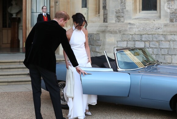 Le prince Harry, duc de Sussex, et Meghan Markle, duchesse de Sussex, habillée d'une robe Stella McCartney et portant une bague sertie d'une aigue-marine ayant appartenu à Lady Diana, quittant le château de Windsor après la réception offerte par Elizabeth II pour rejoindre à bord d'une Jaguar E-Type Concept Zero immatriculée "190518" Frogmore House où avait lieu la réception de leur mariage, le 19 mai 2018.