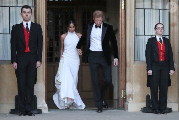Le prince Harry, duc de Sussex, et Meghan Markle, duchesse de Sussex, habillée d'une robe Stella McCartney et portant une bague sertie d'une aigue-marine ayant appartenu à Lady Diana, quittant le château de Windsor après la réception offerte par Elizabeth II pour rejoindre à bord d'une Jaguar E-Type Concept Zero immatriculée "190518" Frogmore House où avait lieu la réception de leur mariage, le 19 mai 2018.