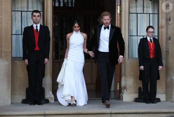 Le prince Harry, duc de Sussex, et Meghan Markle, duchesse de Sussex, habillée d'une robe Stella McCartney et portant une bague sertie d'une aigue-marine ayant appartenu à Lady Diana, quittant le château de Windsor après la réception offerte par Elizabeth II pour rejoindre à bord d'une Jaguar E-Type Concept Zero immatriculée "190518" Frogmore House où avait lieu la réception de leur mariage, le 19 mai 2018.
