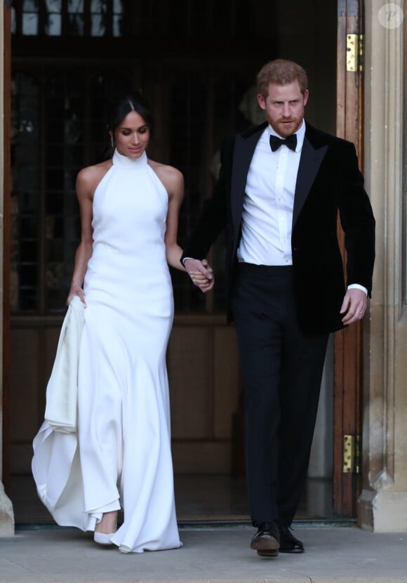 Le prince Harry, duc de Sussex, et Meghan Markle, duchesse de Sussex, habillée d'une robe Stella McCartney et portant une bague sertie d'une aigue-marine ayant appartenu à Lady Diana, quittant le château de Windsor après la réception offerte par Elizabeth II pour rejoindre à bord d'une Jaguar E-Type Concept Zero immatriculée "190518" Frogmore House où avait lieu la réception de leur mariage, le 19 mai 2018.