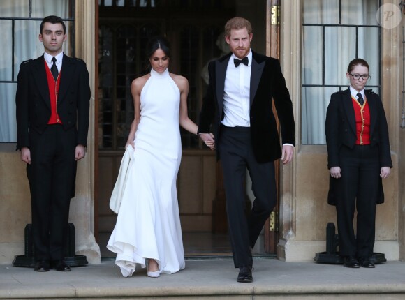 Le prince Harry, duc de Sussex, et Meghan Markle, duchesse de Sussex, habillée d'une robe Stella McCartney et portant une bague sertie d'une aigue-marine ayant appartenu à Lady Diana, quittant le château de Windsor après la réception offerte par Elizabeth II pour rejoindre à bord d'une Jaguar E-Type Concept Zero immatriculée "190518" Frogmore House où avait lieu la réception de leur mariage, le 19 mai 2018.