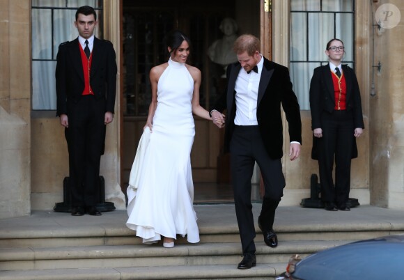 Le prince Harry, duc de Sussex, et Meghan Markle, duchesse de Sussex, habillée d'une robe Stella McCartney et portant une bague sertie d'une aigue-marine ayant appartenu à Lady Diana, quittant le château de Windsor après la réception offerte par Elizabeth II pour rejoindre à bord d'une Jaguar E-Type Concept Zero immatriculée "190518" Frogmore House où avait lieu la réception de leur mariage, le 19 mai 2018.