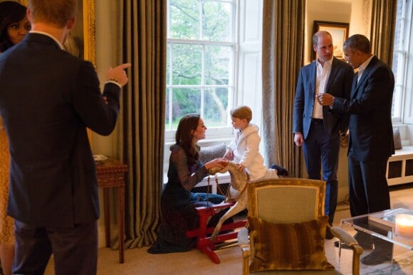 Le prince George de Cambridge sur son cheval à bascule devant Barack Obama et sa femme Michelle Obama rendant visite au prince William et à la duchesse Catherine de Cambridge au palais de Kensington à Londres, le 22 avril 2016.