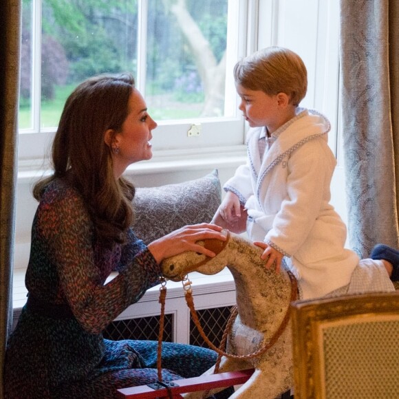 Le prince George de Cambridge sur son cheval à bascule devant Barack Obama et sa femme Michelle Obama rendant visite au prince William et à la duchesse Catherine de Cambridge au palais de Kensington à Londres, le 22 avril 2016.