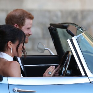 Le prince Harry, duc de Sussex, et Meghan Markle, duchesse de Sussex quittent le château de Windsor à bord d'une Jaguar Type E cabriolet en tenue de soirée après leur cérémonie de mariage, pour se rendre à la réception à "Frogmore House" à Windsor le 19 mai 2018.