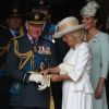 Le prince Charles se fait aider par son épouse Camilla Parker Bowles avec ses gants à l'abbaye de Westminster, le 10 juillet 2018 à Londres, lors du service marquant le centenaire de la Royal Air Force (RAF).