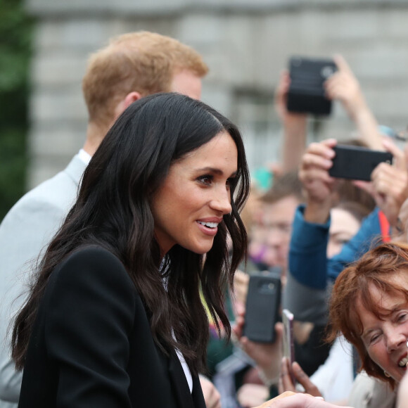 Le prince Harry, duc de Sussex et sa femme Meghan Markle, duchesse de Sussex saluent la foule lors de leur visite au collège de la trinité à Dublin le 11 juillet 2018