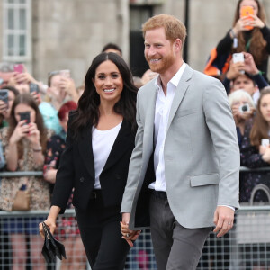 Le prince Harry, duc de Sussex et sa femme Meghan Markle, duchesse de Sussex saluent la foule lors de leur visite au collège de la trinité à Dublin le 11 juillet 2018