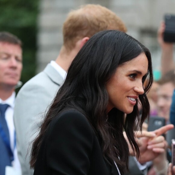 Le prince Harry, duc de Sussex et sa femme Meghan Markle, duchesse de Sussex saluent la foule lors de leur visite au collège de la trinité à Dublin le 11 juillet 2018