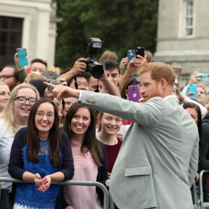 Le prince Harry, duc de Sussex et sa femme Meghan Markle, duchesse de Sussex saluent la foule lors de leur visite au collège de la trinité à Dublin le 11 juillet 2018