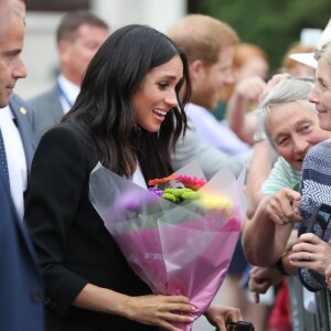 Le prince Harry, duc de Sussex et sa femme Meghan Markle, duchesse de Sussex saluent la foule lors de leur visite au collège de la trinité à Dublin le 11 juillet 2018