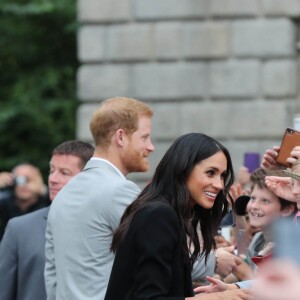 Le prince Harry, duc de Sussex et sa femme Meghan Markle, duchesse de Sussex saluent la foule lors de leur visite au collège de la trinité à Dublin le 11 juillet 2018