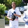 Romeo Beckham et son grand-père (le père de Victoria Beckham) Anthony Adams arrivent au stade de Wimbledon à Londres, le 11 juillet 2018.