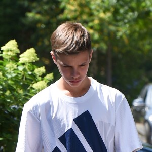 Romeo Beckham et son grand-père (le père de Victoria Beckham) Anthony Adams arrivent au stade de Wimbledon à Londres, le 11 juillet 2018.