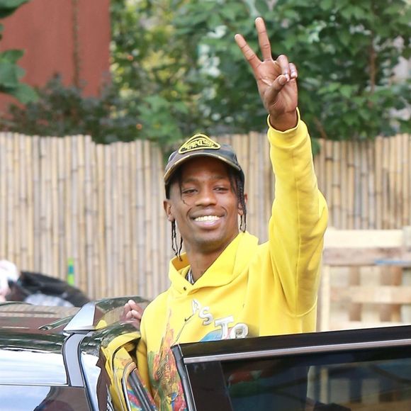 Travis Scott esquisse un rare sourire alors qu'il quitte l'Hôtel Mercer à New York. Le rappeur fait également un signe de paix, le 21 aout 2018.